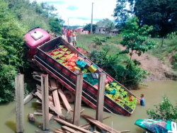 Caminhão, em área rural, carregado de alimentos perecíveis caído em um um rio por causa de quebra de ponte de madeira